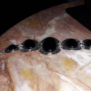 Ornate black stones granulated in silver tone brac